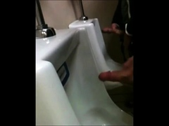 two slim dicks getting wanked at the urinals